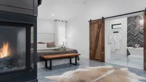 a bedroom with a fireplace and a bed and a table at An Enchanted Hideaway outdoor fireplace hot tub in Fredericksburg