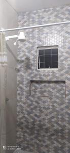 um chuveiro com uma porta de vidro na casa de banho em Casa Confortável em Caruaru