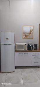 una cucina con frigorifero e forno a microonde su un bancone di Casa Confortável a Caruaru