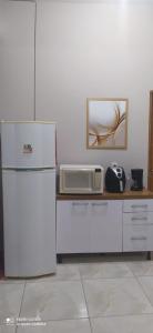 a kitchen with a refrigerator and a microwave on a counter at Casa Confortável com Garagem e internet in Caruaru +11 photos