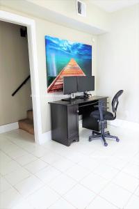 an office with a desk and a computer on a wall at CasaAzul-2605B-Beach & Pleasure Pier a block away in Galveston