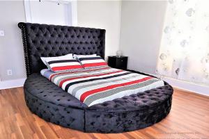 a bed with a black tufted bed frame in a room at CasaAzul-2605B-Beach & Pleasure Pier a block away in Galveston