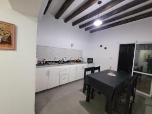 eine Küche mit einem Tisch, einem schwarzen Tisch und Stühlen in der Unterkunft Departamento Mis Nonos 2 in Mendoza