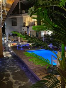 a pool at night with a palm tree in the foreground at Villa LORY in Castellammare di Stabia