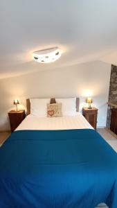 1 dormitorio con 1 cama azul y blanca y 2 lámparas en GITE DES ANGES, en Barret-sur-Meouge