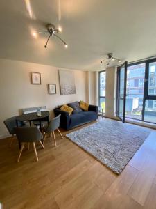 a living room with a blue couch and a table at Holliday Street Apartments - One Bedroom - Stunning Balcony in Birmingham