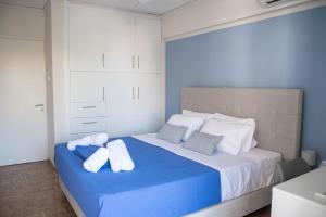a bedroom with a blue and white bed with towels on it at Naiads Nest - The Blue Wave in Varkiza