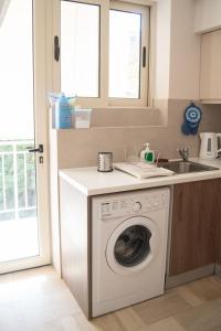 a kitchen with a washing machine and a sink at Naiads Nest - The Blue Wave in Varkiza