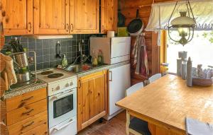 a kitchen with wooden cabinets and a white stove top oven at 3 Bedroom Lovely Home In Arboga in Arboga