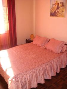 una camera da letto con un letto con cuscini rosa di Villa Herifanja Antsirabe a Antsirabe