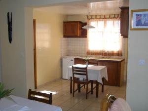eine Küche mit einem Tisch und einem weißen Tisch und Stühlen in der Unterkunft Villa Herifanja Antsirabe in Antsirabe