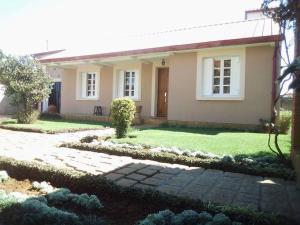 ein kleines Haus mit Rasen davor in der Unterkunft Villa Herifanja Antsirabe in Antsirabe