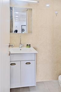 a bathroom with a white sink and a mirror at Orchid sea view apartment in Tel Aviv