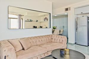 a large couch in a living room with a mirror at Orchid sea view apartment in Tel Aviv