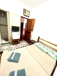 um quarto com uma cama e uma televisão num quarto em Pousada Diniz em Resende