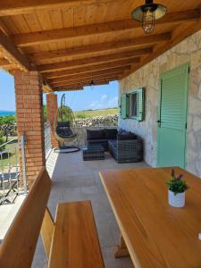 a patio with a table and a couch at Holiday house Adriana in Povljana