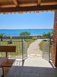 una vista sulla spiaggia da un portico con panchina di Holiday house Adriana a Povljana (Pogliana)