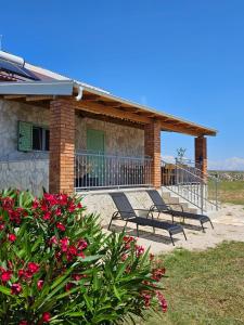 un grupo de bancos sentados fuera de una casa en Holiday house Adriana en Povljana