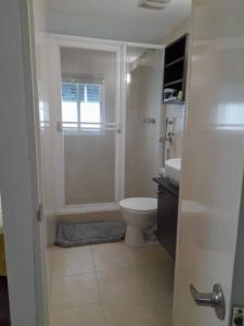 a white bathroom with a shower and a toilet at R.1105 Estudio Ejecutivo, céntrico y funcional. in Panama City