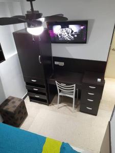 a room with a desk with a tv and a chair at R.1105 Estudio Ejecutivo, céntrico y funcional. in Panama City
