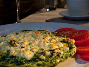 una pizza en un plato en una mesa con tomates en Palacio de Marquesa, en Taos