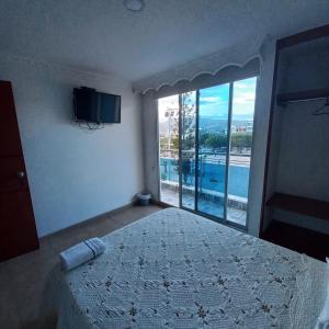 a bedroom with a bed and a large window at HOTEL PLAZA 6 in Sogamoso