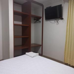 a bedroom with a bed and a tv and shelves at HOTEL PLAZA 6 in Sogamoso +17 photos