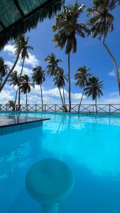 a large swimming pool with palm trees in the background at Eco Paradise 110 - Cumbuco in Caucaia