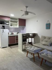 a kitchen and a living room with a couch and a table at Pé na Areia no Cumbuco - Eco Paradise 110 in Caucaia