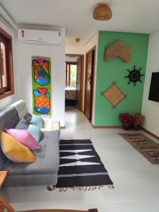 a living room with a gray couch and a green wall at Flat em Taipu de Fora - Cond Vila Taipu in Barra Grande