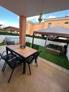 une terrasse avec une table, des chaises et un parasol dans l'établissement La casa Latina, à Vinaròs