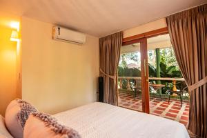 a bedroom with a bed and a balcony at Portales del Tayrona Garden Hotel in Calabazo