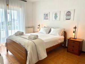 a bedroom with a large bed with two towels on it at Colina do Elétrico in Figueira da Foz