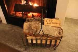 a sign on a cart in front of a fireplace at Il Focolare - Attico centrale di charme in Sauze dʼOulx