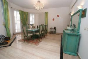 una sala da pranzo con tavolo e sedie verdi di Elba Luxury Villa a Sharm El Sheikh