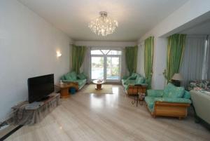 un soggiorno con mobili verdi e lampadario a braccio di Elba Luxury Villa a Sharm El Sheikh
