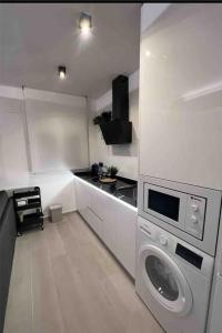 uma cozinha branca com uma máquina de lavar roupa em Apartamento marqués em Madri
