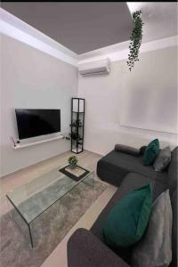 salon z kanapą i telewizorem z płaskim ekranem w obiekcie Apartamento marqués w Madrycie