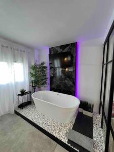 baño con una gran bañera blanca con iluminación púrpura en Apartamento marqués en Madrid