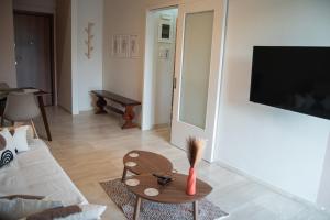 a living room with a couch and a table at Naiads Nest - The Cozy Retreat in Varkiza