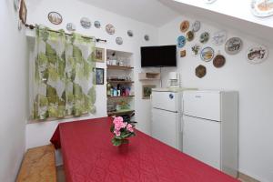 cocina con mesa roja y nevera blanca en Rooms with WiFi Brsec, Opatija - 7768, en Brseč