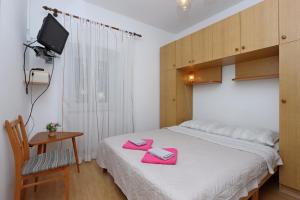 Un dormitorio con una cama con toallas rosas. en Rooms with WiFi Brsec, Opatija - 7768, en Brseč