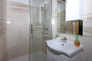 y baño blanco con lavabo y ducha. en Rooms with WiFi Brsec, Opatija - 7768, en Brseč