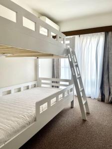 - un lit superposé blanc dans un dortoir avec une échelle dans l'établissement 大山駅徒步4分平层90㎡超大客厅光线充沛（池袋至近）, à Tokyo