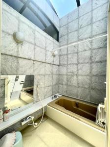 W łazience znajduje się wanna i lustro. w obiekcie 大山駅徒步4分平层90㎡超大客厅光线充沛（池袋至近） w Tokio