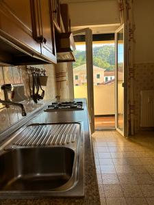 una cucina con lavandino in acciaio inossidabile e finestra di Ampio trilocale con posto auto a Sestri Levante