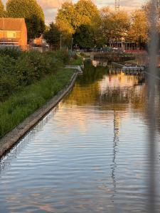 a river with a reflection in the water at Mona's Home in Dagenham