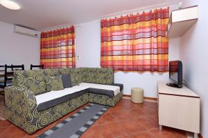 un soggiorno con divano e TV di Apartments by the sea Selce, Crikvenica - 18195 a Selce