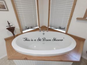a bath tub with a sign in a bathroom at Cozy Cottage in Miramonte