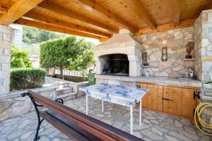 an outdoor kitchen with a table and a stove at Apartments with parking space Mrljane, Pasman - 20056 in Pašman +11 photos